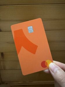 A happy customer holding an orange Ready Lite card in their hand